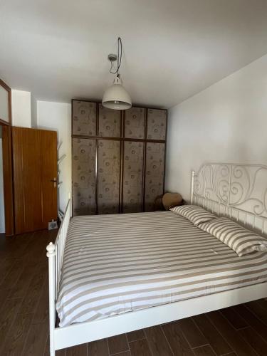 a bedroom with a white bed with a wooden floor at Le maree in Grado