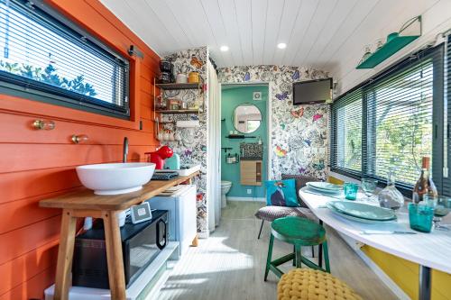 ノヴにあるLa roulotte de Valouのオレンジ色の壁とシンクのあるキッチン