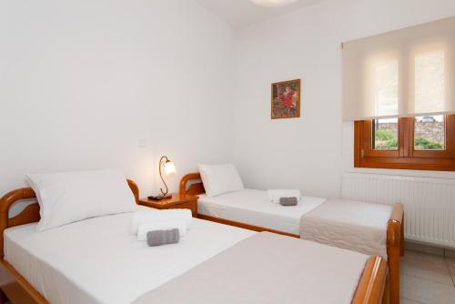 a bedroom with two beds and a window at Aggeliki's House in Kamarai
