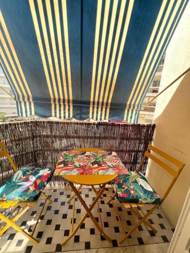 une table et deux chaises sur un balcon dans l'établissement Appartement Rex, à Nice
