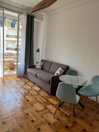 un salon avec un canapé, une table et des chaises dans l'établissement Appartement Rex, à Nice