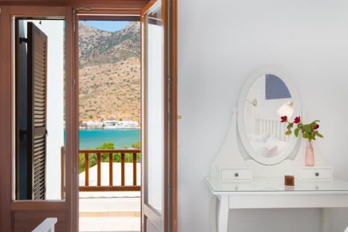 a room with a table and a mirror and a balcony at Aggeliki's House in Kamarai
