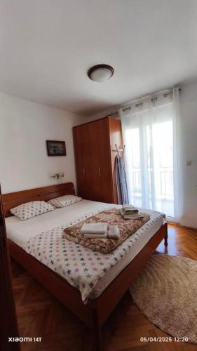 a bedroom with two beds and a large window at PRCPORTOapartmani in Herceg-Novi