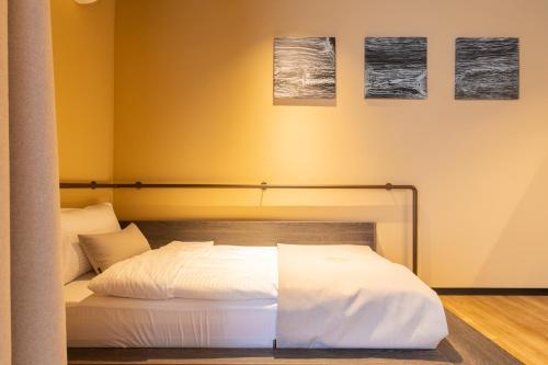 a bed in a room with three pictures on the wall at Agara Stays Prizren in Prizren