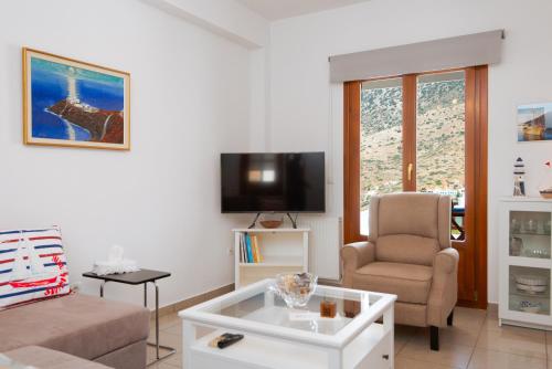 a living room with a couch and a chair and a tv at Aggeliki's House in Kamarai