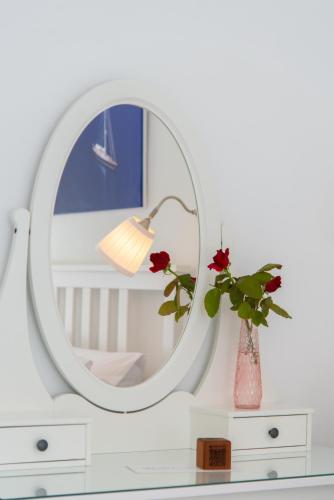 a mirror on top of a dresser with a vase at Aggeliki's House in Kamarai