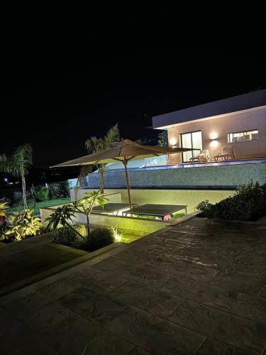 taras z parasolem przy basenie nocą w obiekcie Villa w mieście Kelibia