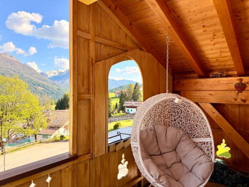 a swing in a cabin with a window at Casa mia - vall di fassa in Vigo di Fassa