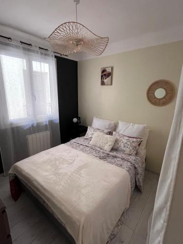 une chambre avec un lit et un lustre dans l'établissement Charmante maison de ville, à Saint-Laurent-du-Var