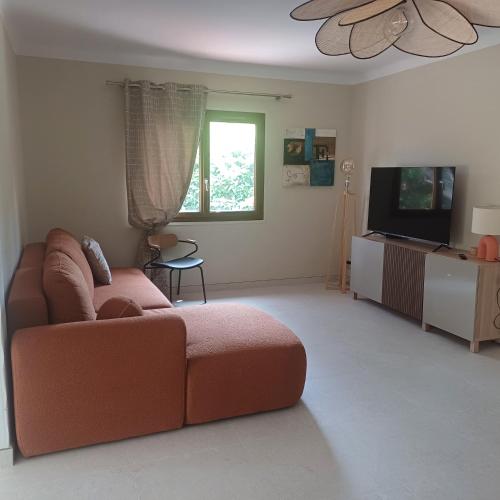 un salon avec un canapé et une télévision à écran plat dans l'établissement Lesmiens, à Saint-Raphaël