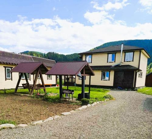 a house with a picnic table and a bench at Котедж 7я in Verkhovyna