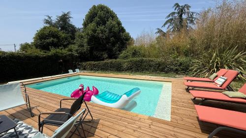 una piscina con gonfiabili e sedie di maison cocon a Saint-Loubès