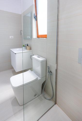 a white bathroom with a toilet and a shower at Vila Erti Berat in Berat