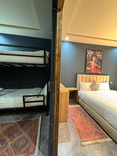 a bedroom with two bunk beds and a mirror at Playa Surf House in Tamraght Ouzdar