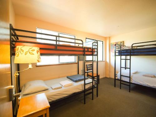 two bunk beds in a room with a desk and a desk at Ashland Commons Hostel in Ashland