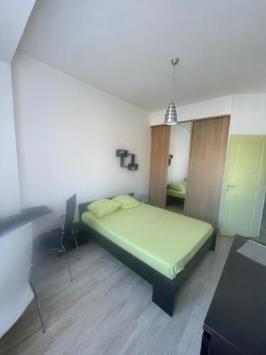 - une chambre avec un lit vert et un bureau dans l'établissement Le Peyron lumineux et air conditionné, à Saint-Raphaël