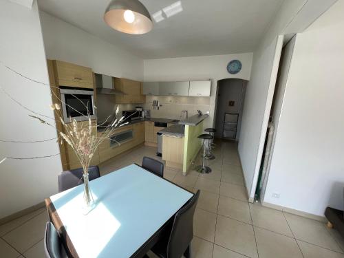une cuisine avec une table avec un vase dessus dans l'établissement Le Peyron lumineux et air conditionné, à Saint-Raphaël