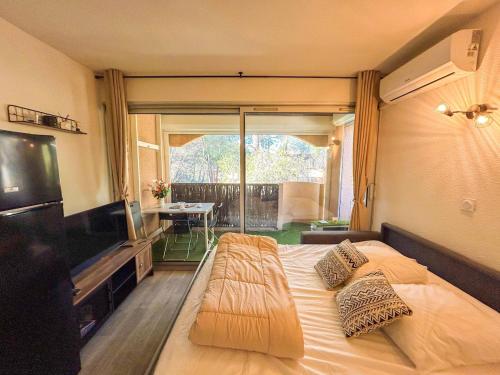une chambre avec un grand lit et une télévision à écran plat dans l'établissement Studio dans une résidence avec piscine à Sanary, à Sanary-sur-Mer