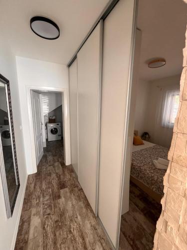 a corridor of a room with a bed and a mirror at Apartmani la Barquera in Brodarica