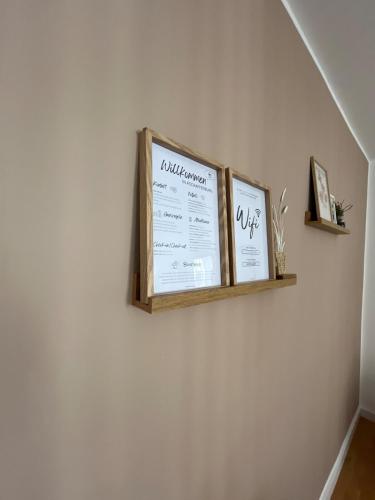 a shelf on a wall with two pictures on it at Gemütliches Apartment I Mitten in der Stadt Aschaffenburg I 5 Min HBF I Gegenüber City Galerie in Aschaffenburg