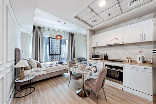 eine Küche und ein Wohnzimmer mit einer Couch und einem Tisch in der Unterkunft Stylish Urban Stay at Marina, Studio with All Essentials in Dubai