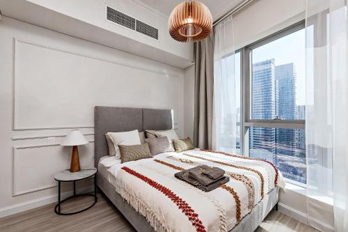 ein weißes Schlafzimmer mit einem Bett und einem großen Fenster in der Unterkunft Stylish Urban Stay at Marina, Studio with All Essentials in Dubai