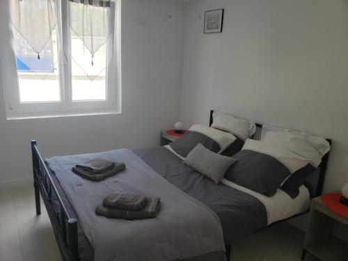 - un lit avec 2 serviettes dans une chambre dans l'établissement Appartement T3 3 étoiles à 4 km de la plage, à Tarnos