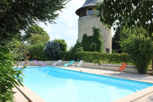 une piscine avec des chaises et un phare en arrière-plan dans l'établissement Le Moulin de Margaux, à Margaux