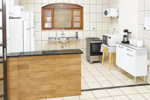 une cuisine avec un évier et un plan de travail dans l'établissement casa do fred enseada, à Guarujá