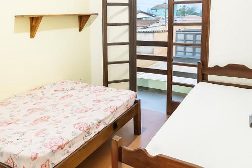 une chambre avec deux lits superposés et une échelle dans l'établissement casa do fred enseada, à Guarujá