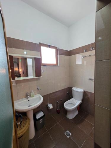 a bathroom with a toilet and a sink at Maison de Fabjon in Ksamil
