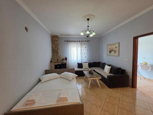 a living room with a bed and a couch at Maison de Fabjon in Ksamil