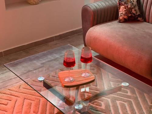 a glass table with two wine glasses on top of a couch at ZENHOME luxury appartement in Dilida