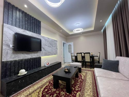 a living room with a couch and a tv on a wall at Urban Luxe Retreat- Pogradec in Pogradec