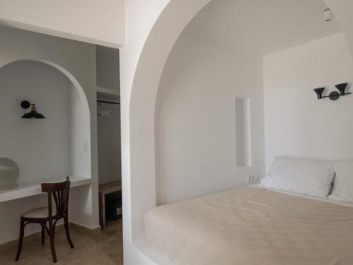 a bedroom with a bed and a table and a chair at VERANNA Patmos D4 in Patmos