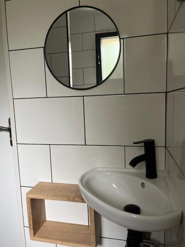 a bathroom with a sink and a mirror at Maison Osithe in Doudeauville
