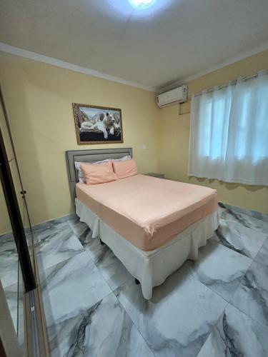 a bedroom with a bed with marble floors at Brisa Do mar Apartamento 2 in Cabo Frio