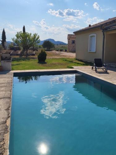 - une piscine avec une chaise à côté d'une maison dans l'établissement maisonette, à Barjac
