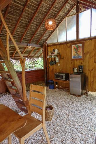 a room with a table and a chair in a cabin at Fare Tearenui - Tu'i'anina Village Huahine in HUH
