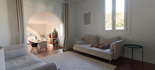 un salon avec un canapé blanc et une table dans l'établissement Maison de ville avec grande terrasse à Caneta, à Hendaye