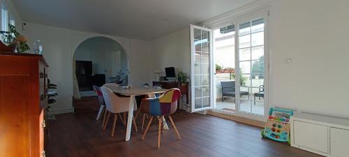 une salle à manger avec une table et des chaises dans une pièce dans l'établissement Maison de ville avec grande terrasse à Caneta, à Hendaye