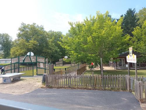 a park with a wooden fence and a playground at Le Kraken in Aureilhan