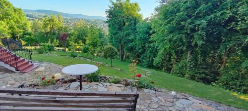 a park with a bench and an umbrella and a garden at Mieszkanko z tarasem in Limanowa