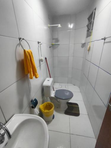 a white bathroom with a toilet and a sink at Casa próximo ao Centro da cidade in Campina Grande