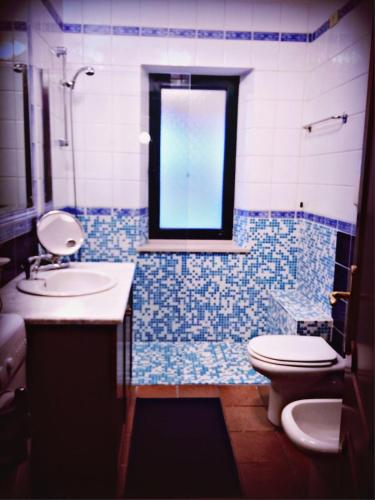 a bathroom with a sink and a toilet and a window at Casa Vacanze Villa Flumini in Flumini di Quartu