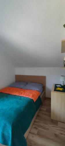 a bedroom with a bed and a side table at Mieszkanko z tarasem in Limanowa