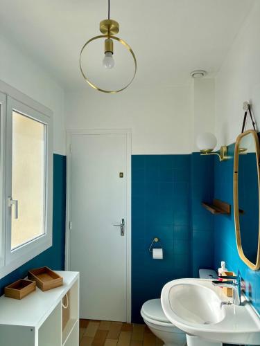 La salle de bains est pourvue de toilettes blanches et d'un mur bleu. dans l'établissement Sunset Studio Air conditionner and Lake Access, aux Salles-sur-Verdon