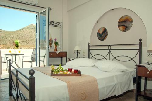 a bedroom with a large bed and a balcony at Anastasia Studios in Avlemonas