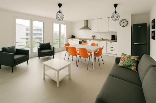 un salon avec un canapé, une table et des chaises dans l'établissement Tiya-Gare Champs sur Marne-Parking Gratuit, à Champs-sur-Marne