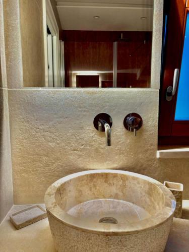 a stone sink in a bathroom with a mirror at La Posta del Guardiano in Vieste